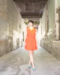 Colour blocked with yellow beads, orange dress, turquoise shoes.