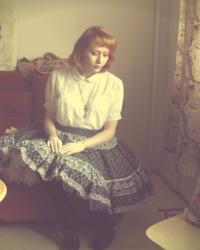 Porcelain doll - with a pile of books.