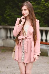 Różowy płaszcz, koronkowa sukienka i pikowana torebka
