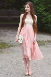 Plisowana pastelowa spódnica, koronkowe body i cieliste szpilki