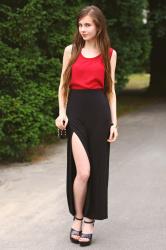 Czarna spódnica z rozcięciem, czerwony top i skórzane sandały