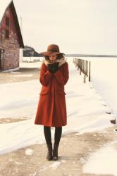 wearing: big orange coat and a floppy hat