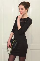 Czarna koronkowa sukienka z odkrytym tyłem, pikowana torebka i lakierowane szpilki