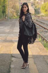 Un look total black e una maxi bag con frange 