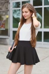 Szara bluzka, czarna spódniczka mini i torba listonoszka