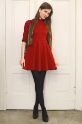 Czerwona sukienka, czarne rajstopy i elegancka torebka