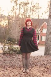 Outfit: Sleeveless Black Dress over a Plaid Shirt, Herringbone Tights, and Bronze Shoes