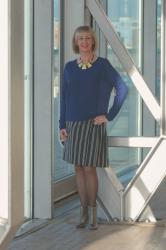 A blue sweater with a blue and cream striped skirt