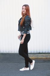 Czarna skórzana kurtka, koszulka w czarno białe paski, białe slip on, luźna stylizacja