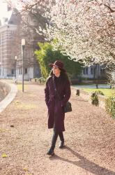 Outfit: robe coat and hat under the first spring blossoms