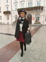 Czarny płaszczyk, bordowa spódniczka i kapelusz 