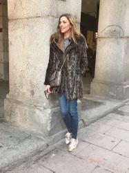 fur coat, vestido y jeans con sneakers