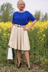 Bright blue top with a camel, pleated skirt