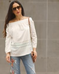 Blusa blanca con los hombros al descubierto, jeans bordados y cuñas Magrit