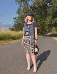 Country time:  styling a ruffled gingham skirt with a graphic tee, denim vest, ankle boots, and a baker boy cap
