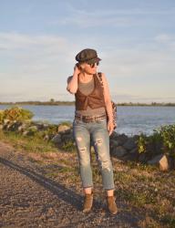 Golden:  distressed cropped jeans, booties, biker vest, and a baker boy hat