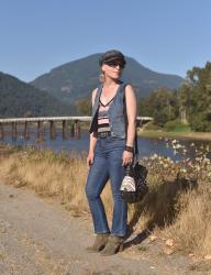 Turn the page: cropped flare jeans with a striped tank, denim vest, ankle boots, and a baker boy hat