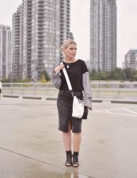 Mix and match: sweatshirt with statement sleeves, black denim skirt, cut-out booties, and a cross-body bag