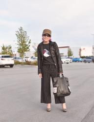 Goodies: Bird-motive sweater, striped cropped trousers, moto jacket, leopard pumps, and a military-style cap