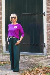 Wide green trousers with a purple jumper