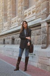 Look con vaqueros, botas altas y americana gris