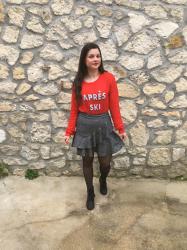 Look en pull rouge, jupe carreaux à volants et bottines noires