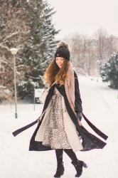 Jak nosić czarny płaszcz zimą? Stylizacja z sukienką w cętki