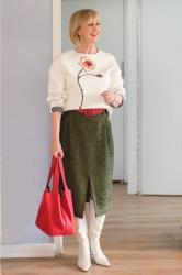A green midi skirt with a cream sweater