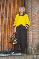 Wide black trousers and a big yellow jumper