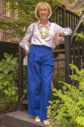 Cobalt blue trousers with a green and white necklace by Angela Caputi