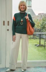 Green jumper with cream trousers