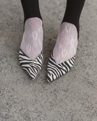 Black trench coat, heel-strap leggings, and zebra mules