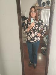 Outfit propio: Blusa negra floreada de moño + jeans amplios azul oscuro.
